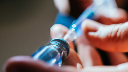 Syringe drawing liquid medication from a pharmaceutical vial, representing drug development, injectable therapies, and analytical testing.