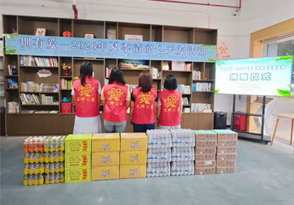 Intertek colleagues in branded clothing stand with their backs to donated items. 