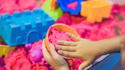 Boy playing with kinetic sand in preschool. The development of fine motor concept. Creativity Game concept