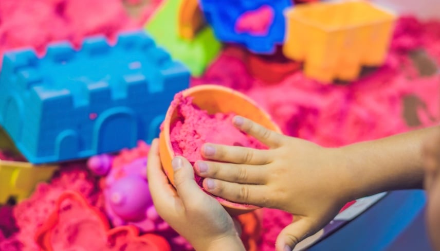 Boy playing with kinetic sand in preschool. The development of fine motor concept. Creativity Game concept