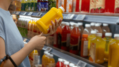 Consumer holds drink bottle in a supermarket representing PPWR compliance and packaging safety
