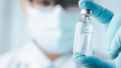 Scientist holds a pharmceutical vial representing extractables and leachables studies