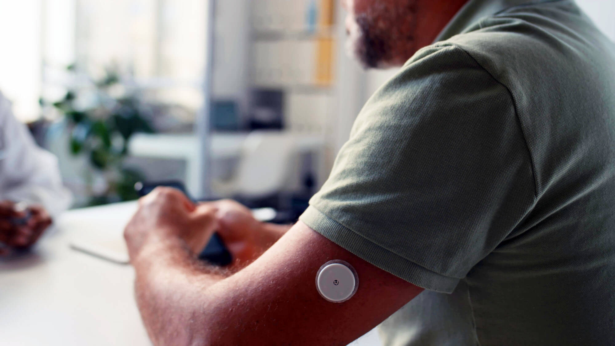 Close-up shot of middle-aged Caucasian man with diabetes sitting in gp clinic