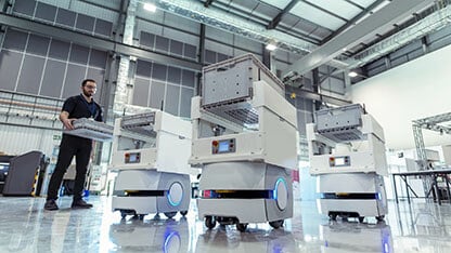 Worker with factory storage robots in warehouse storage research factory