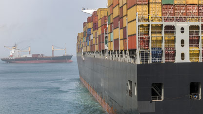 Rear view of large cargo container ship on the water