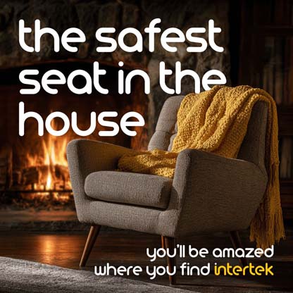 A lounge chair with a throw blanket in a room next to a fireplace