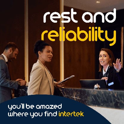 A woman engaging with the attendant at a hotel reception desk